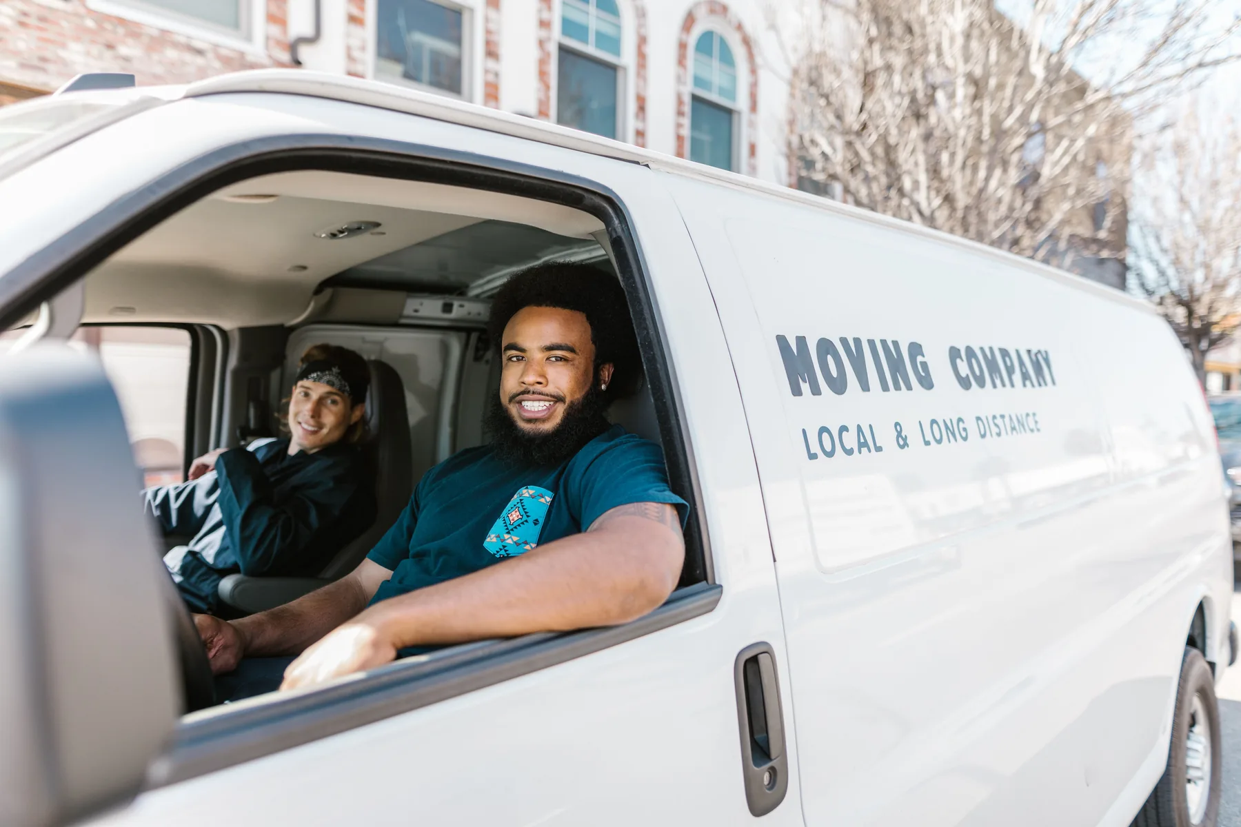 Professional moving team beside a moving vehicle